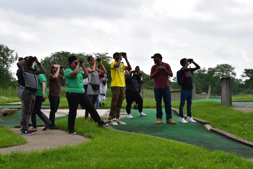 Teens look through binoculars at Douglass Park 