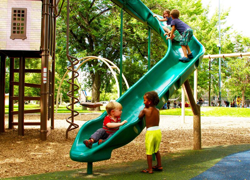 A green slide in a playground.