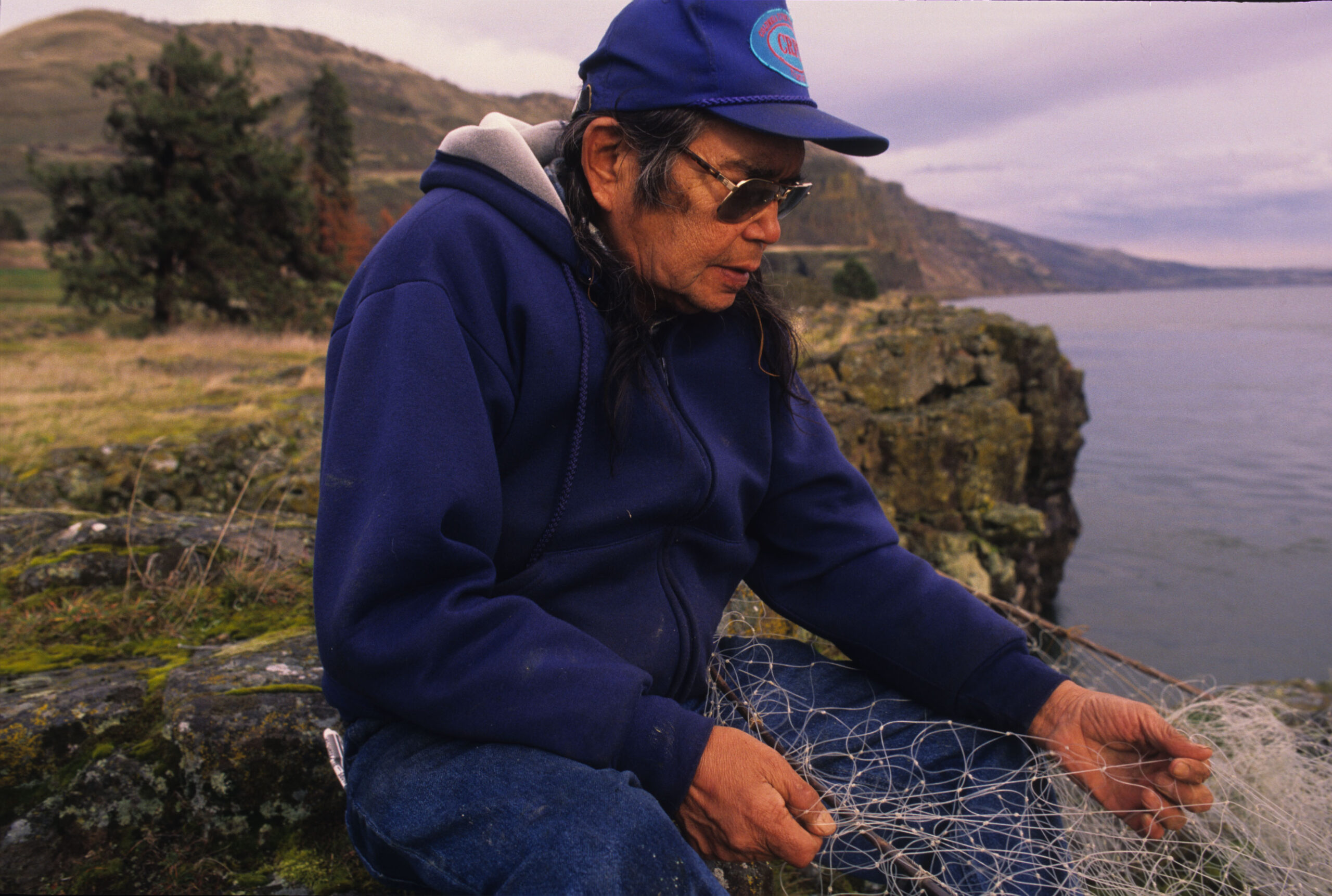 A man in a blue hat holding a fishing net.
