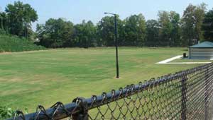 A grassy field with a chain link fence.