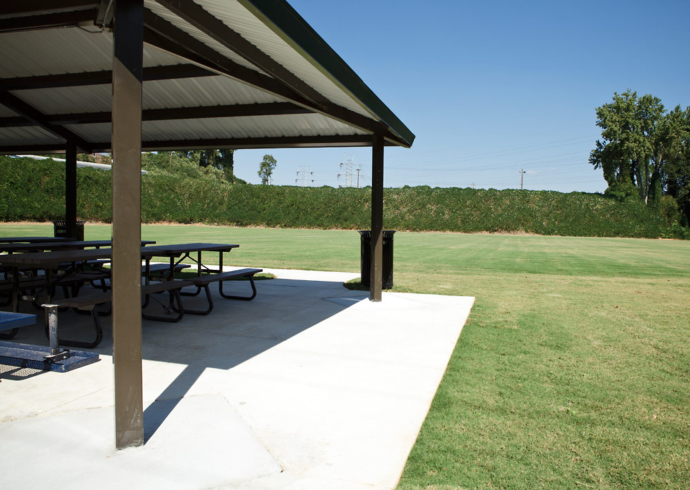 A covered picnic table in a grassy area.