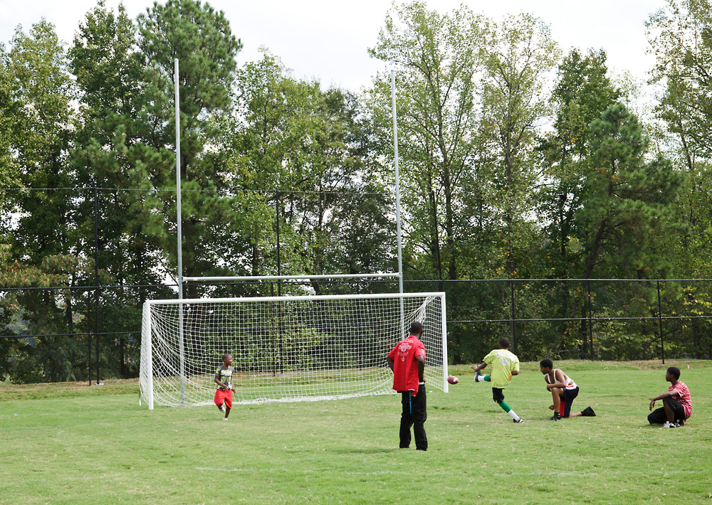 A group of kids playing soccer in a field.