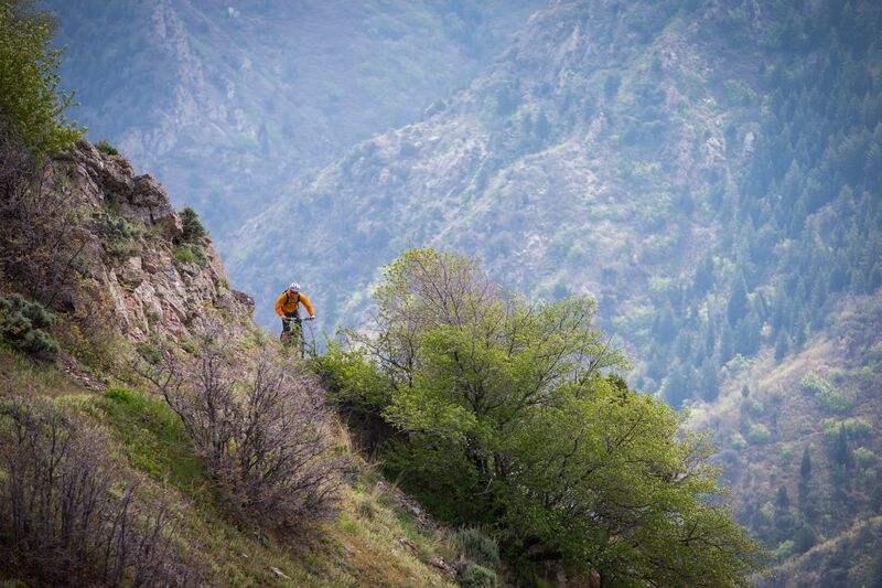 A man riding a mountain bike on the side of a cliff.