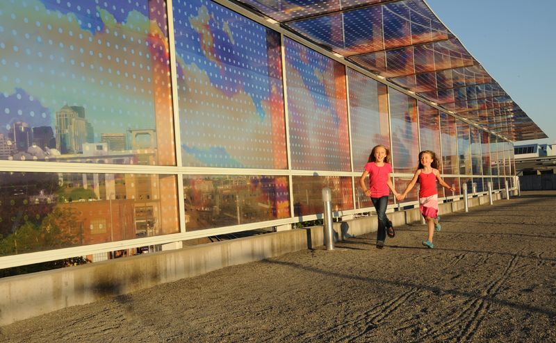 Two girls walking along a walkway with solar panels.
