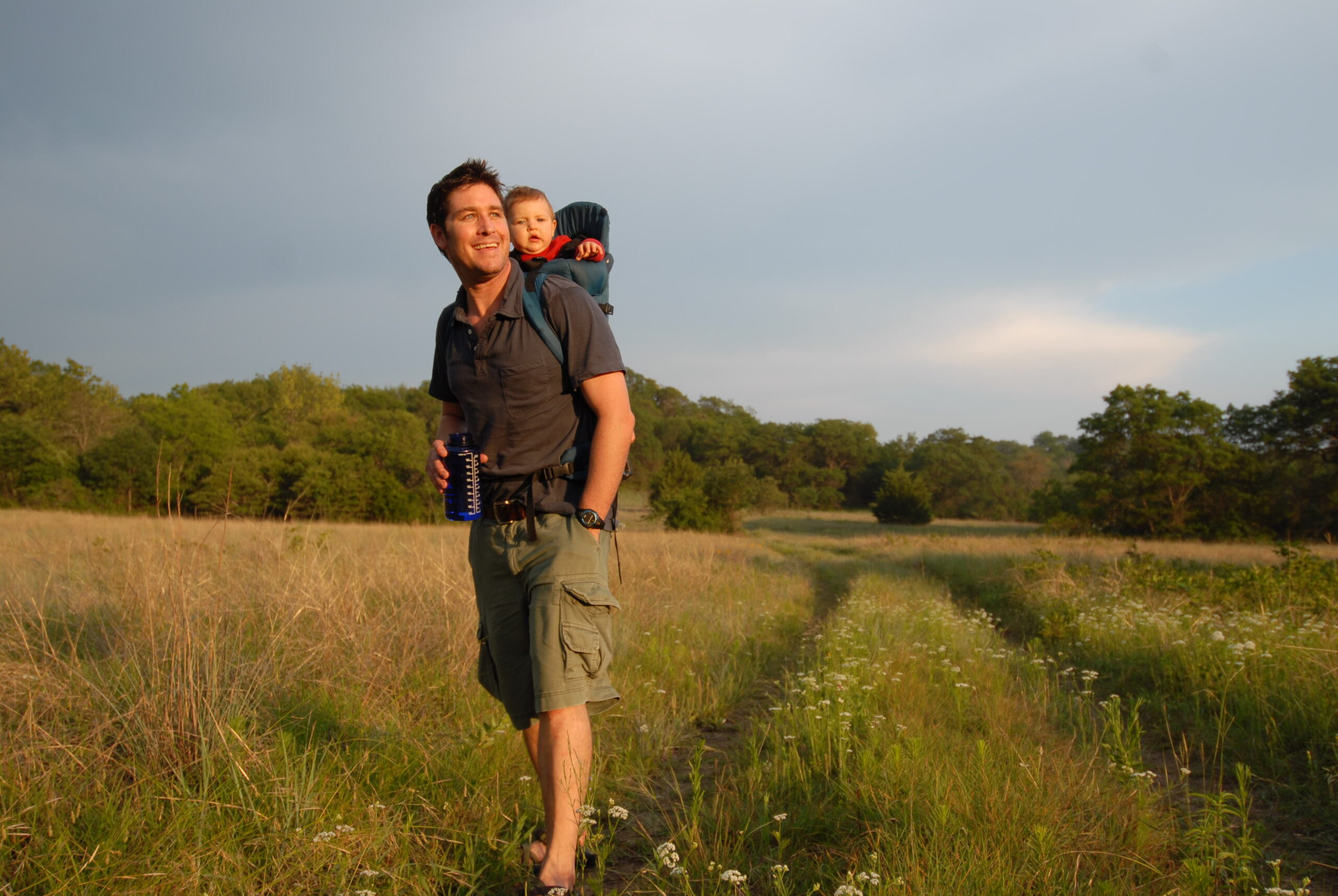 A man walking with a child in a field.