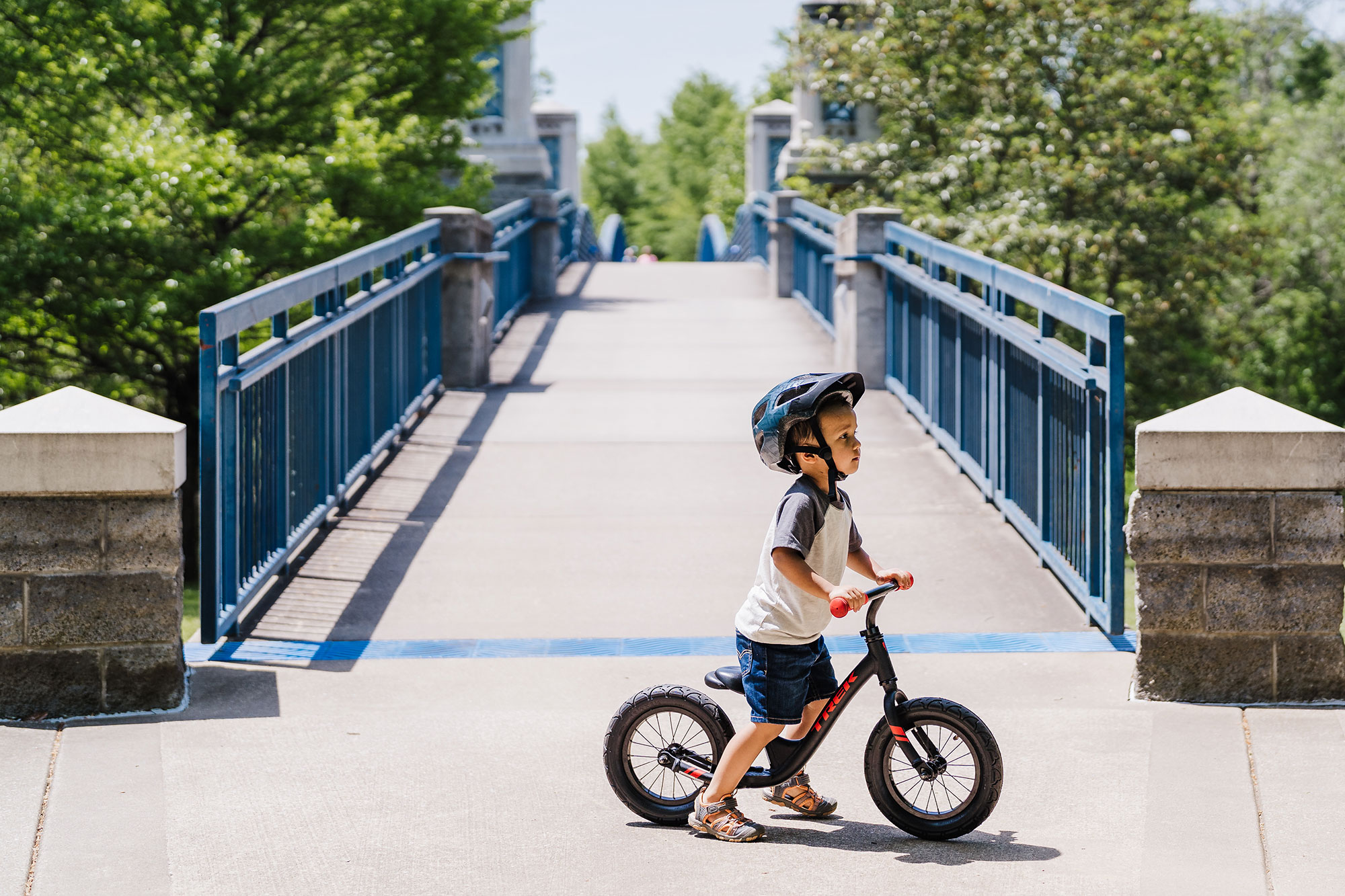 A young boy riding a bike on a bridge.