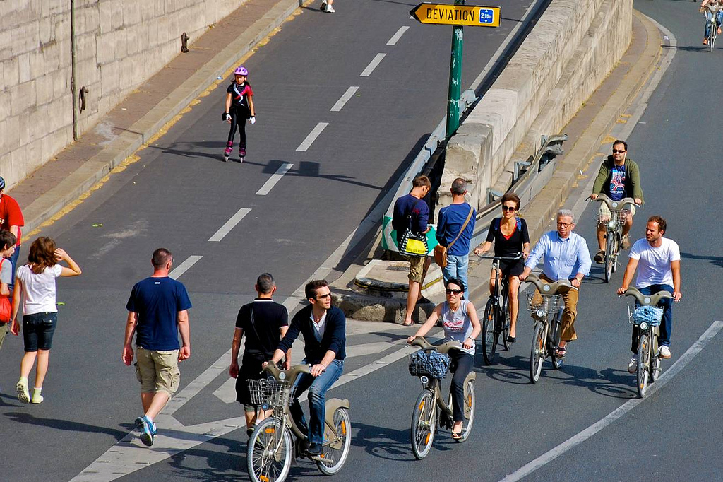 A group of people riding bicycles down a street.