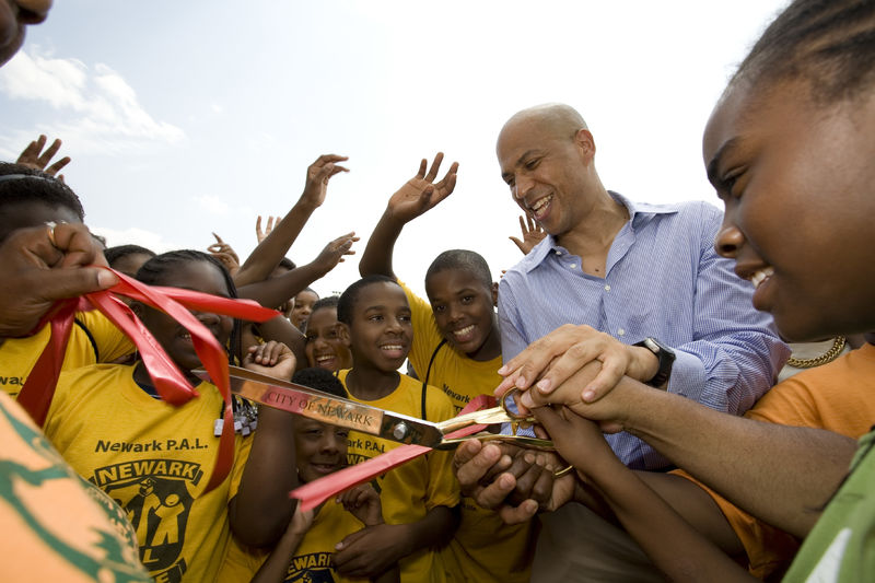 Former Newark, NJ mayor Cory Booker cuts a ribbon surrounded by school kids