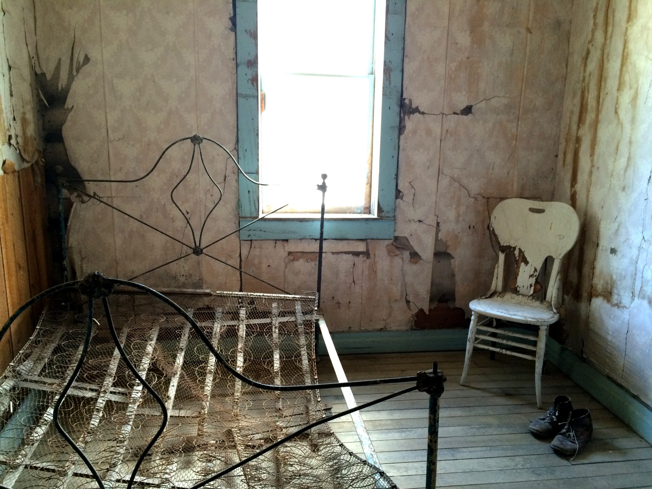 A rusty bedspring in an abandoned room