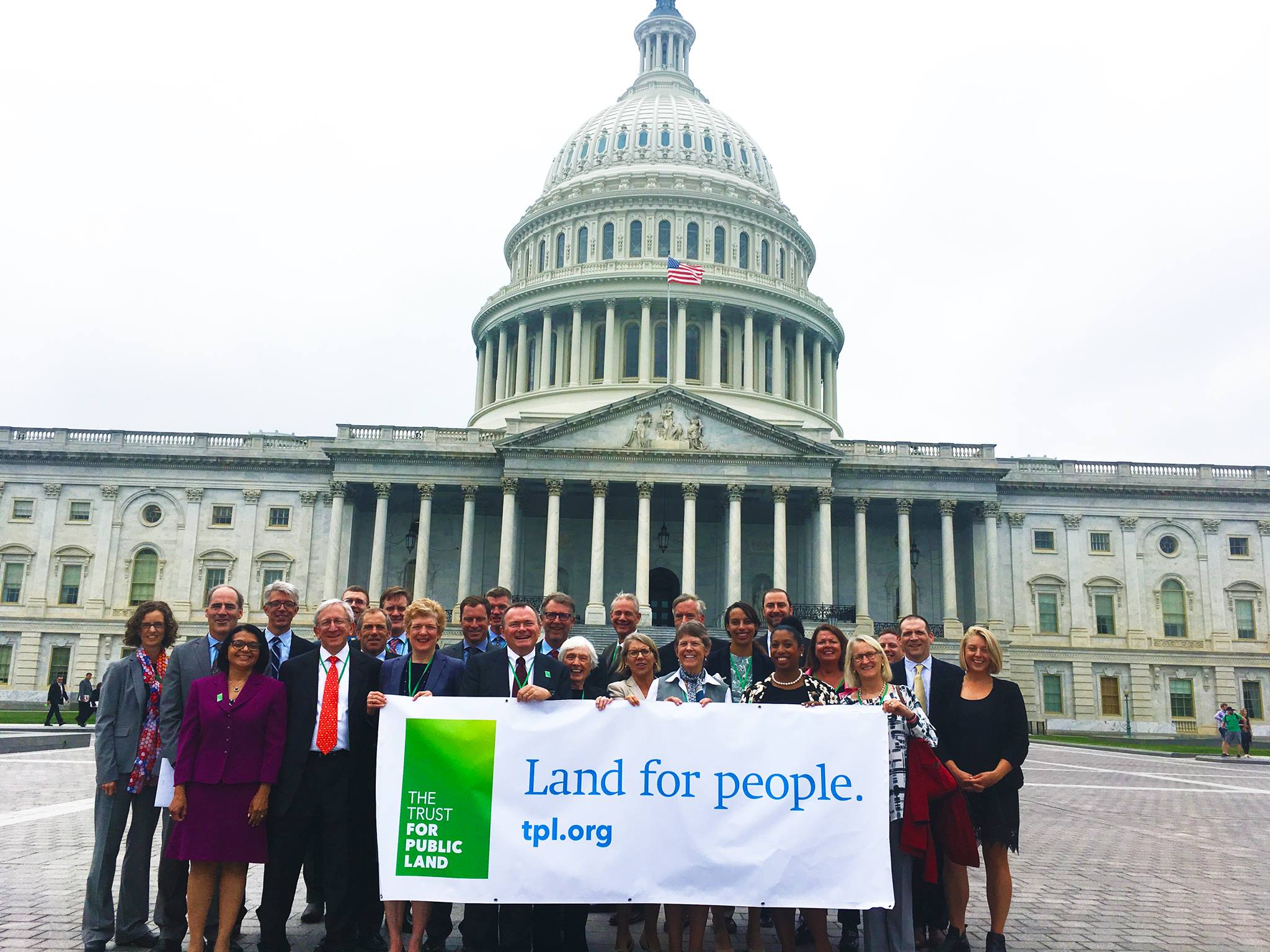 Trust for Public Land volunteers pose with a banner before the U.S. Capitol