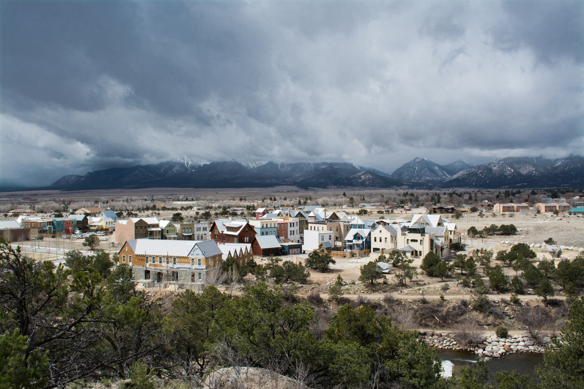 A small town in a mountain valley under cloudy skies