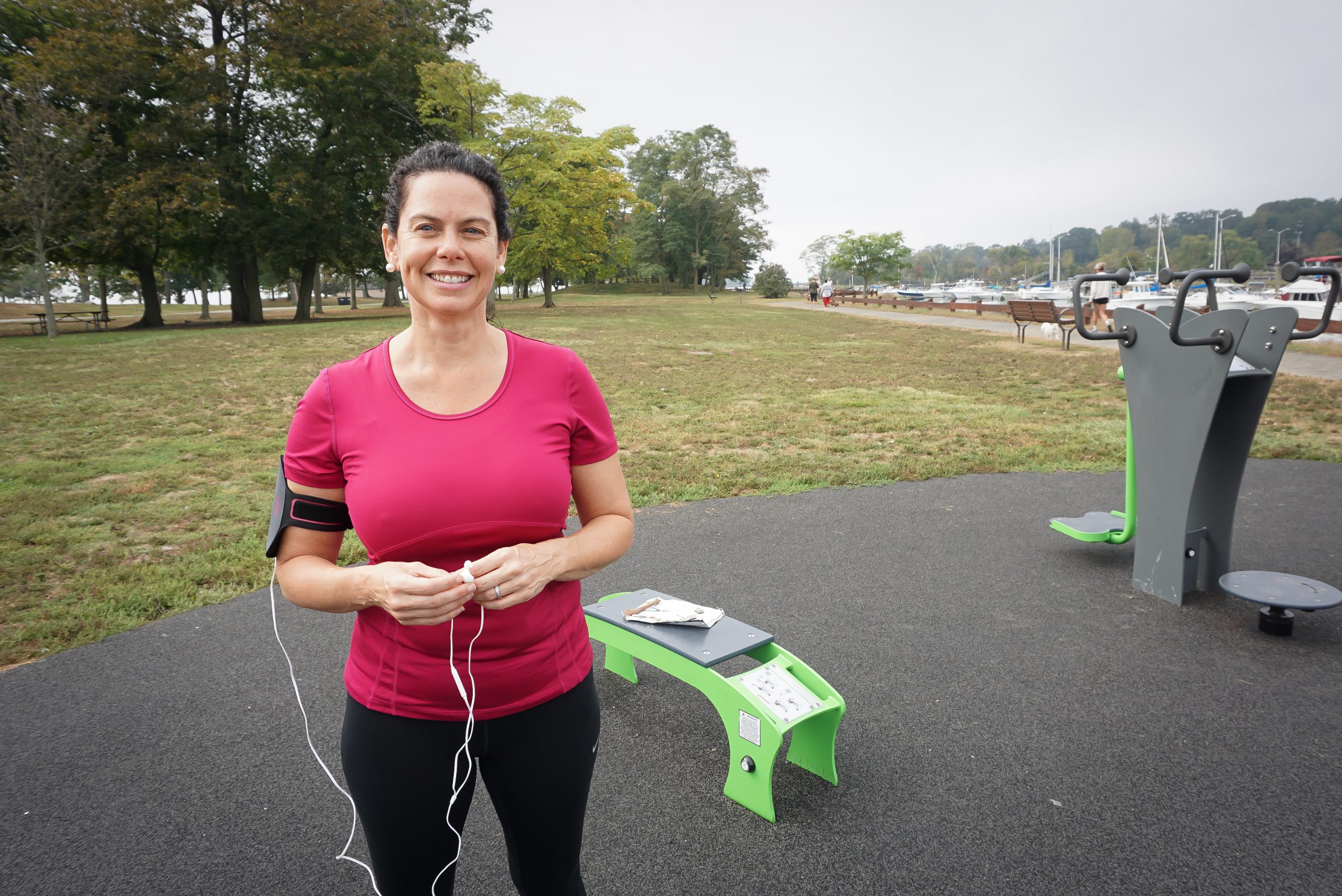 A woman in workout garb at an outdoor exercise area