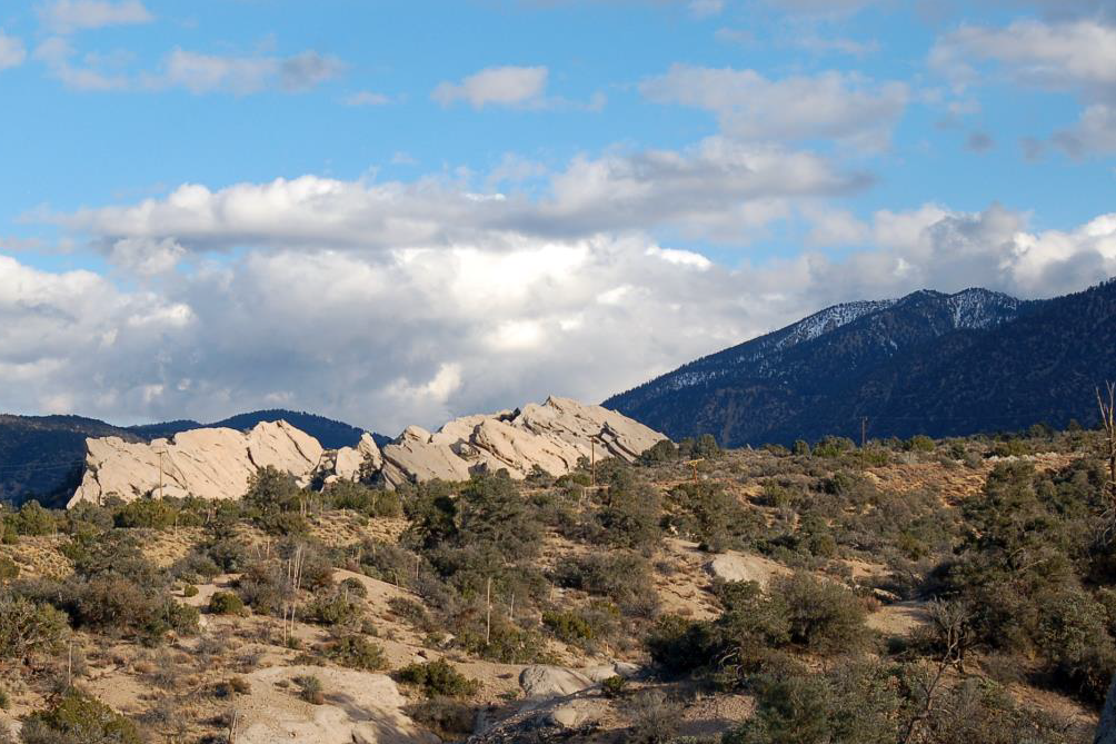 Desert rock formations and snowy mountains in the background