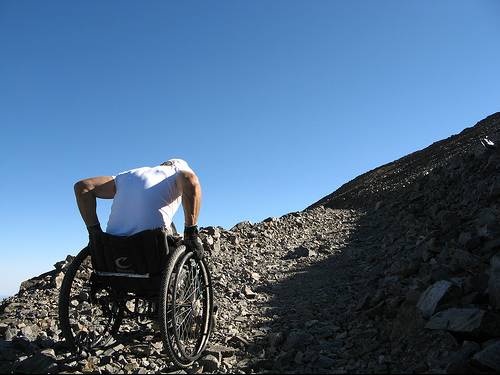 A man in a wheelchair on a high mountain trail