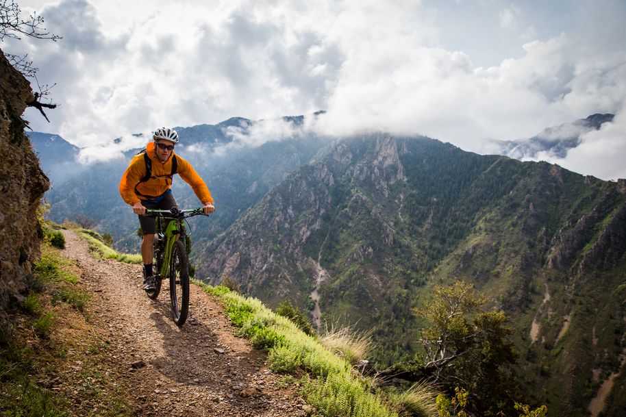 A man bikes on a trail on a mountain