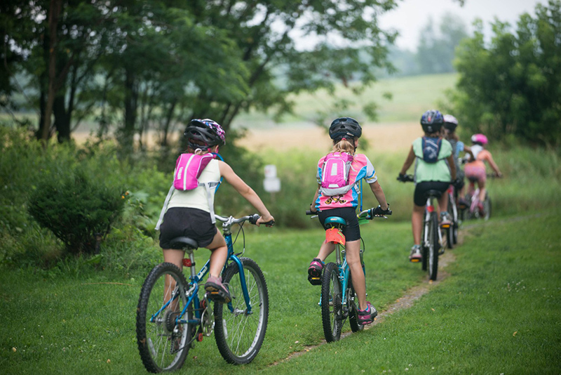 Girls ride bikes in a field
