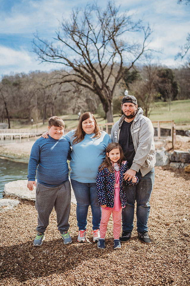 A family posing for a photo in front of a lake.