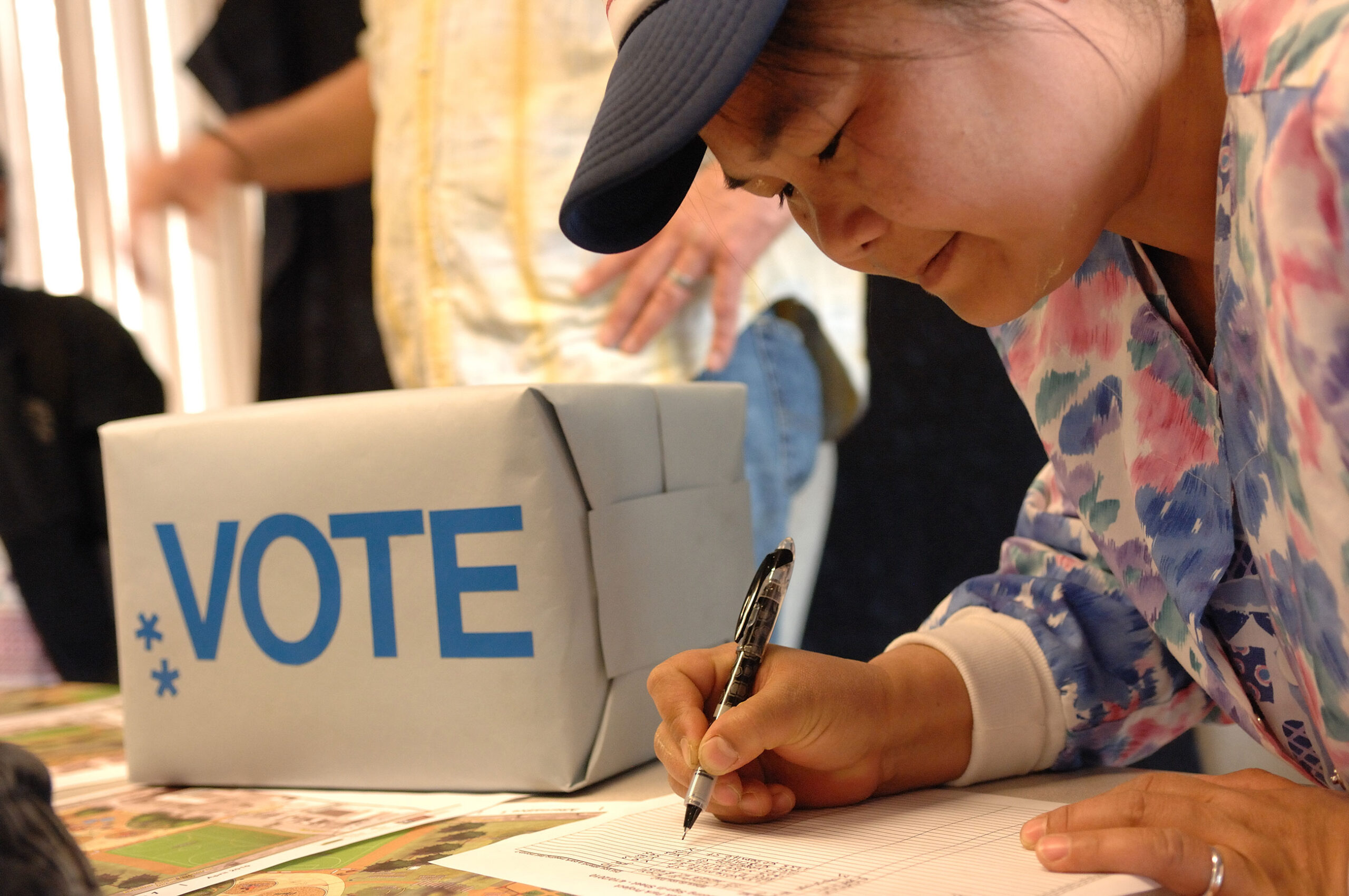 A woman signing a ballot.