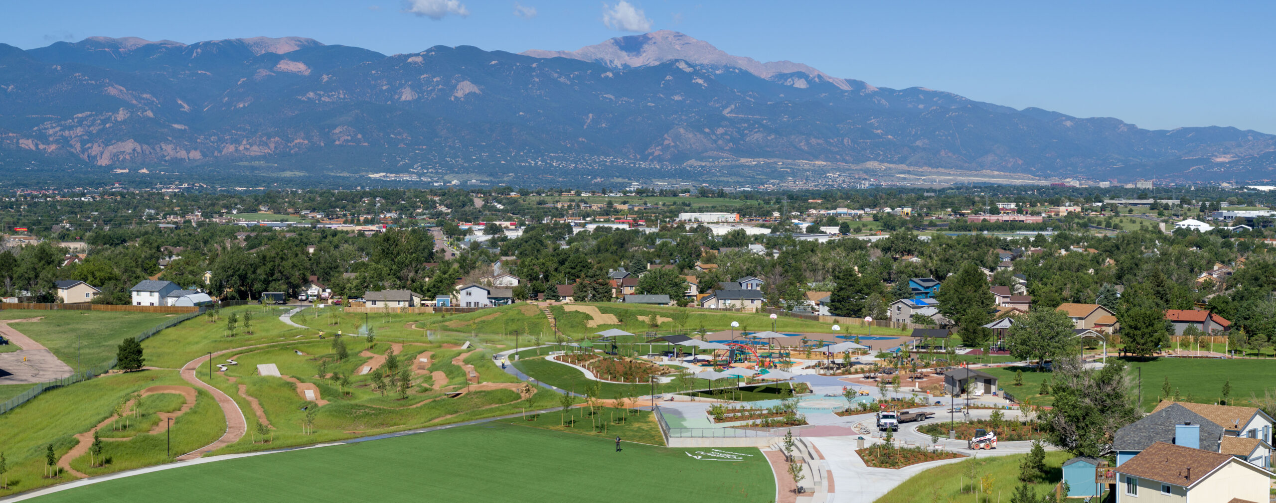 An aerial view of a park with mountains in the background.