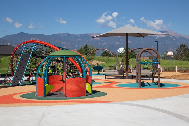 A colorful playground with mountains in the background.