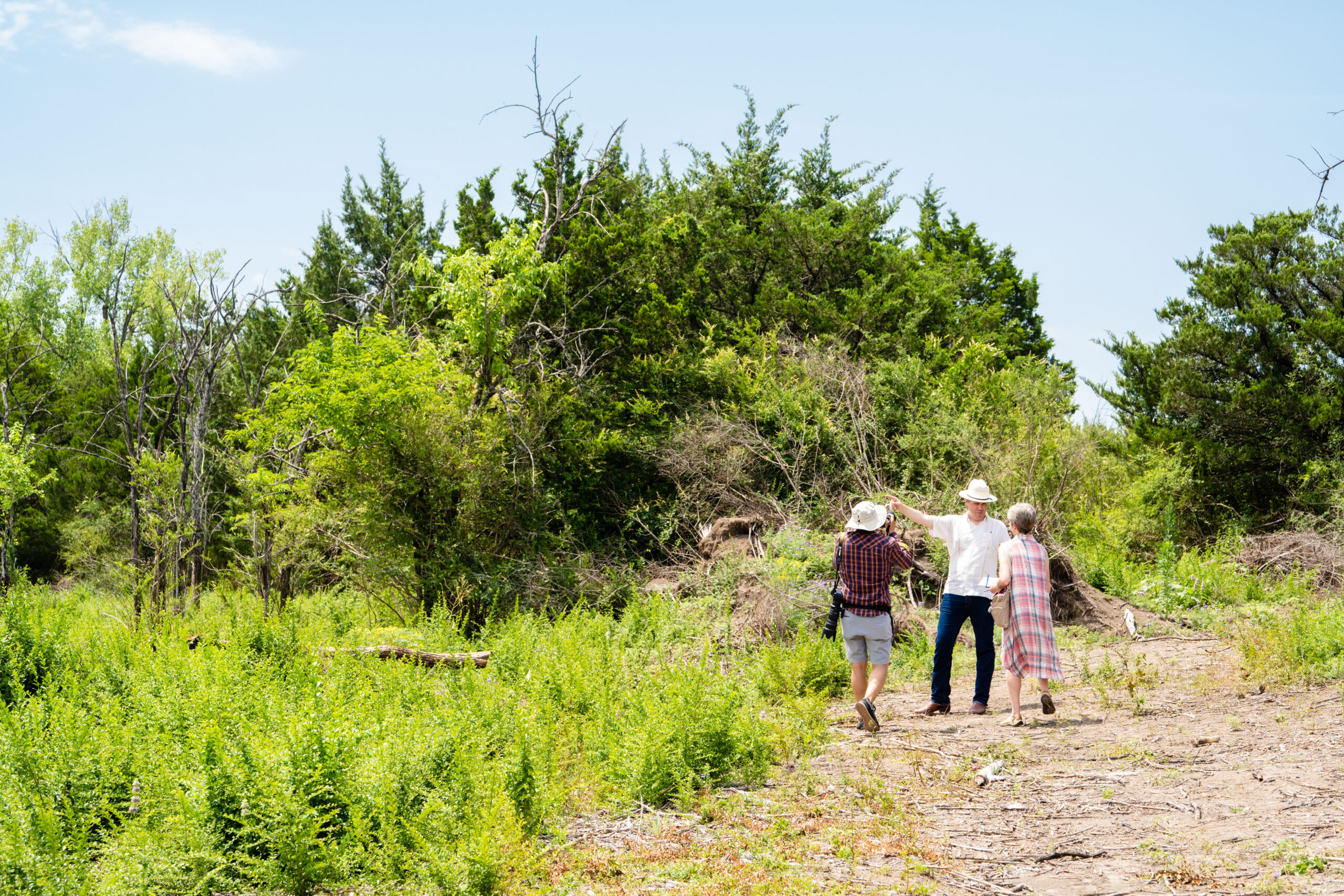 A group of people walking down a dirt path.