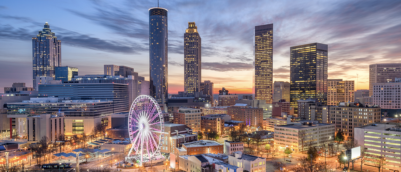 Atlanta skyline at dusk with ferris wheel.