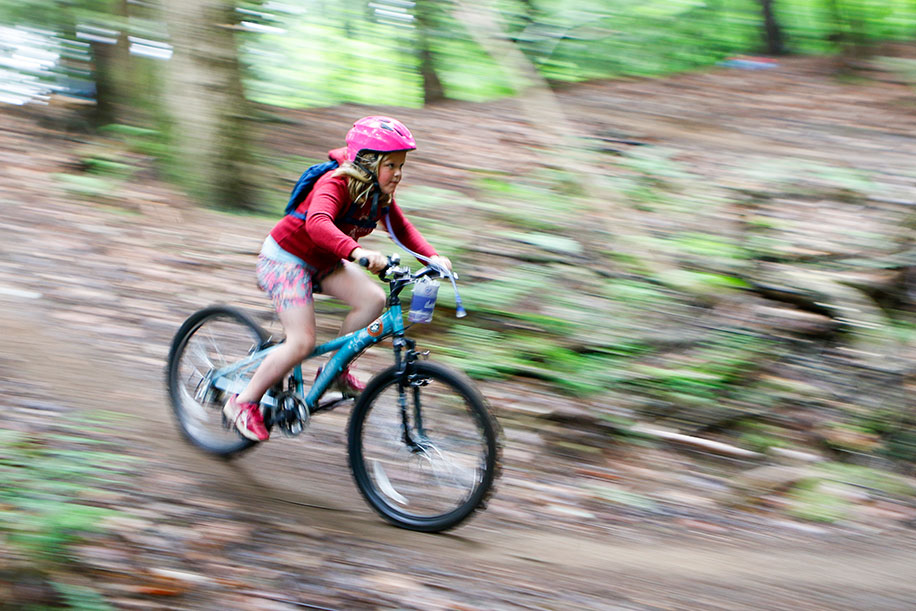 A woman riding a mountain bike in the woods.