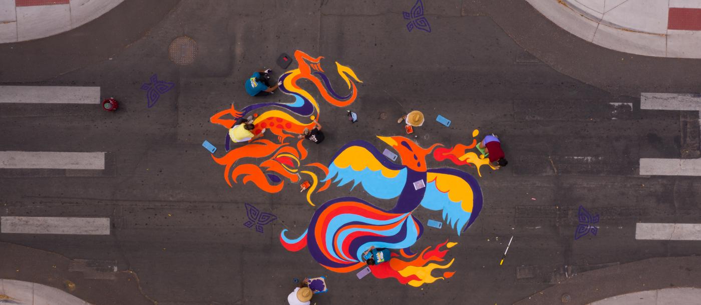 An aerial view of a colorful painting on a street.