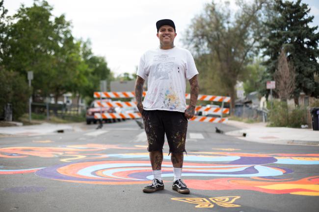 Santiago Jaramillo stands in front of a mural he helped design in Westwood