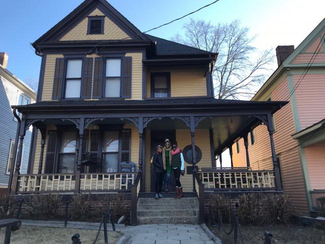 A woman and two teenagers on the porch of MLK's childhood home