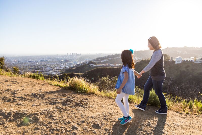 A woman and girl walk along the edge of a canyon in California's Hollywood Hills.