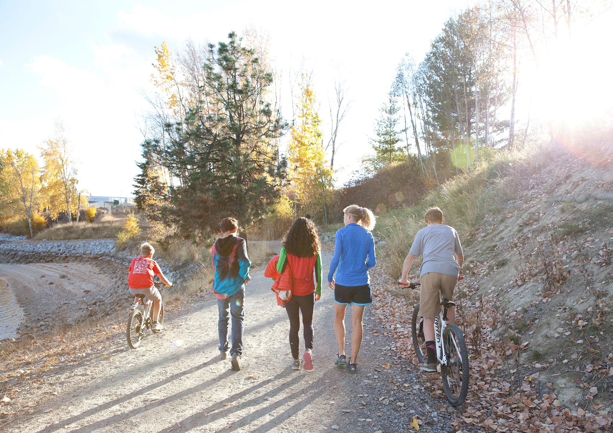 A group of kids riding bikes on a dirt path.