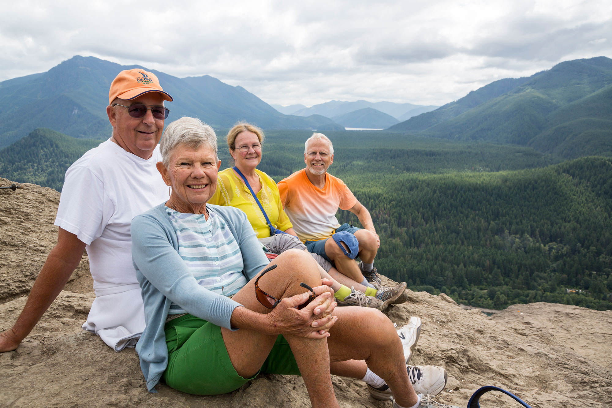 A group of older people sitting on top of a mountain.