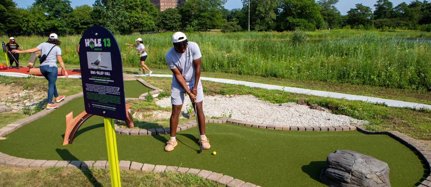 A man playing golf on a miniature golf course.