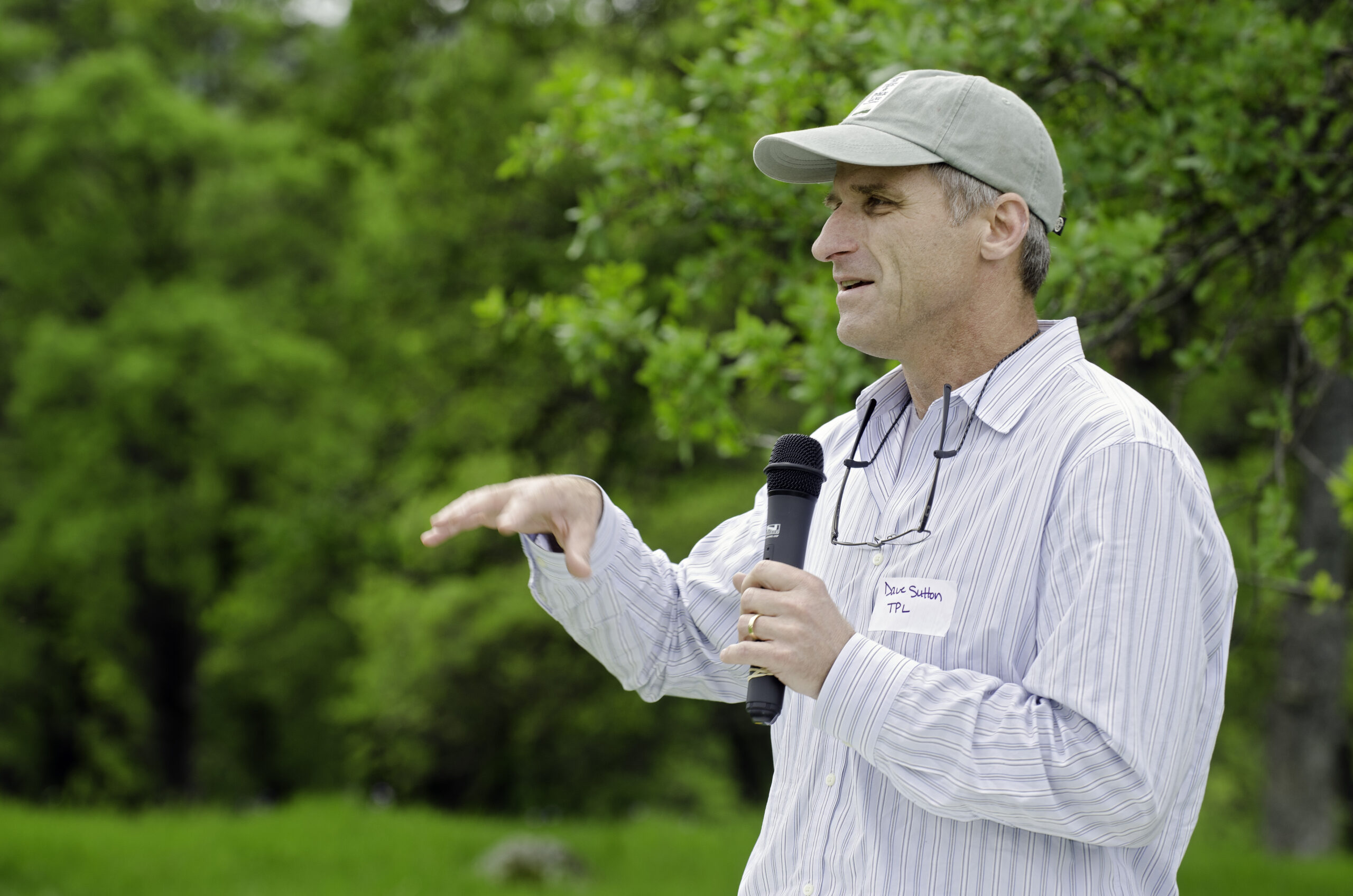 A man holding a microphone in a field.