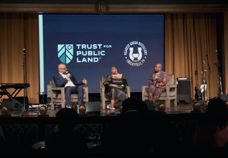 A group of people on stage at a trust for public land event.
