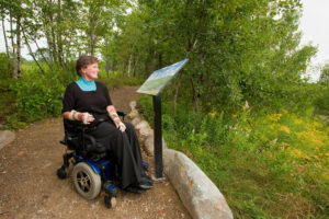 A woman enjoying the view in Greenfield, New Hampshire, where Trustfor Public Land partnered with a foundation to create a 3-mile accessible trail that winds through woods and wetlands. Photo: Al Karevy Photography